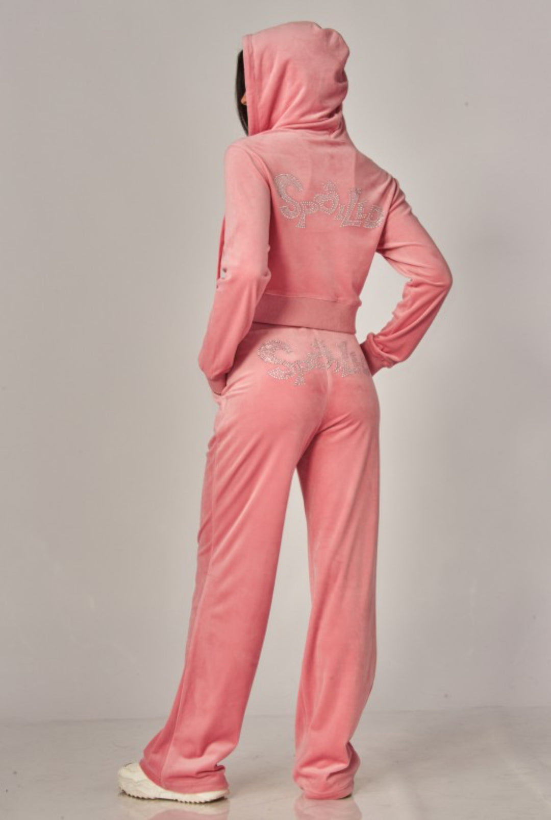 Pink tracksuit with lace detailing on a plain background