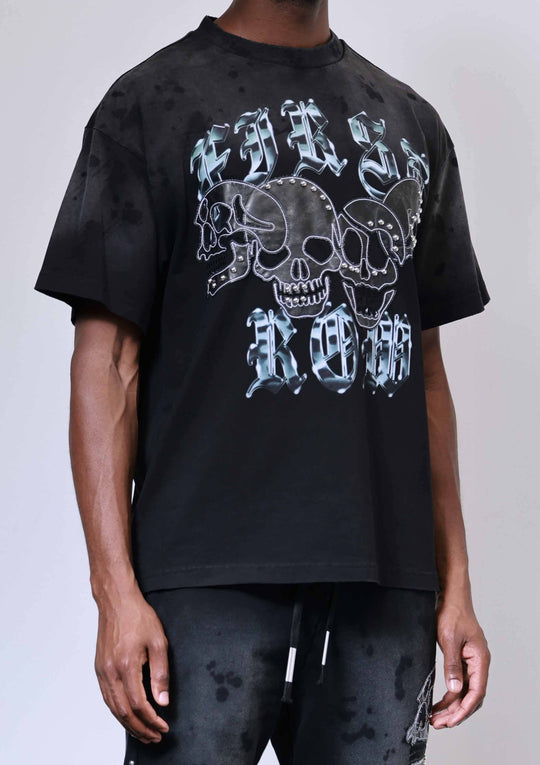 Person wearing a black t-shirt with skull and crossbones design on a plain background
