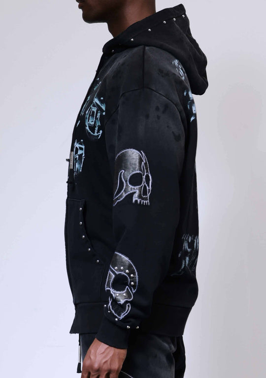 Black hoodie with skull designs on a plain background