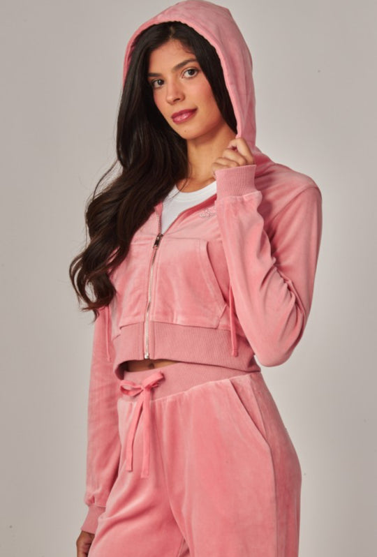 Woman wearing a pink tracksuit against a plain background