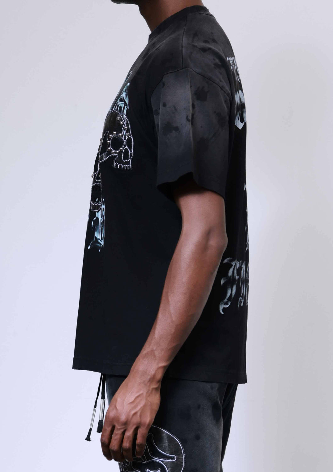 Person wearing a black t-shirt with white graphics against a white background