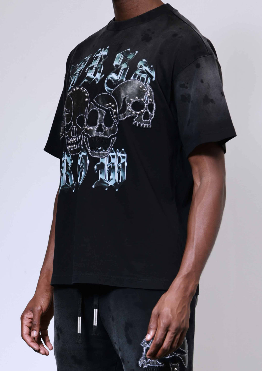 Person wearing a black t-shirt with a graphic design on a plain background