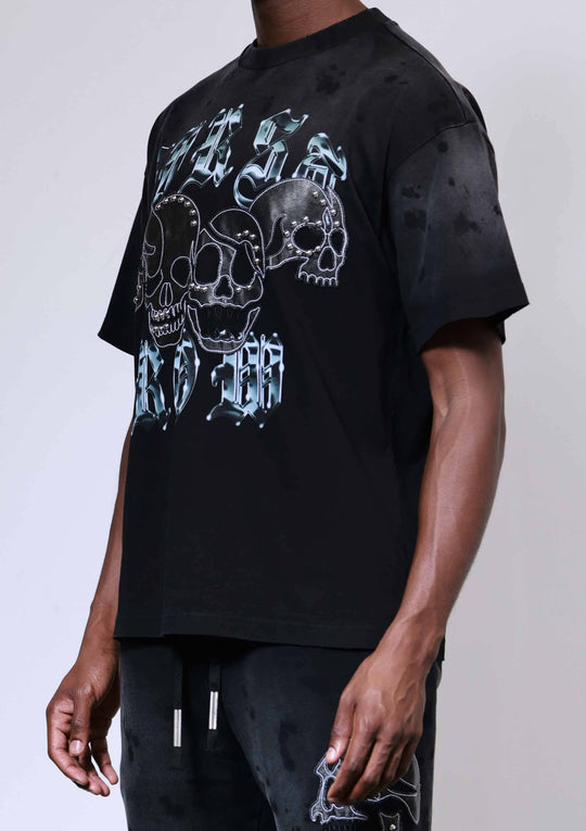 Person wearing a black t-shirt with a graphic design on a plain background